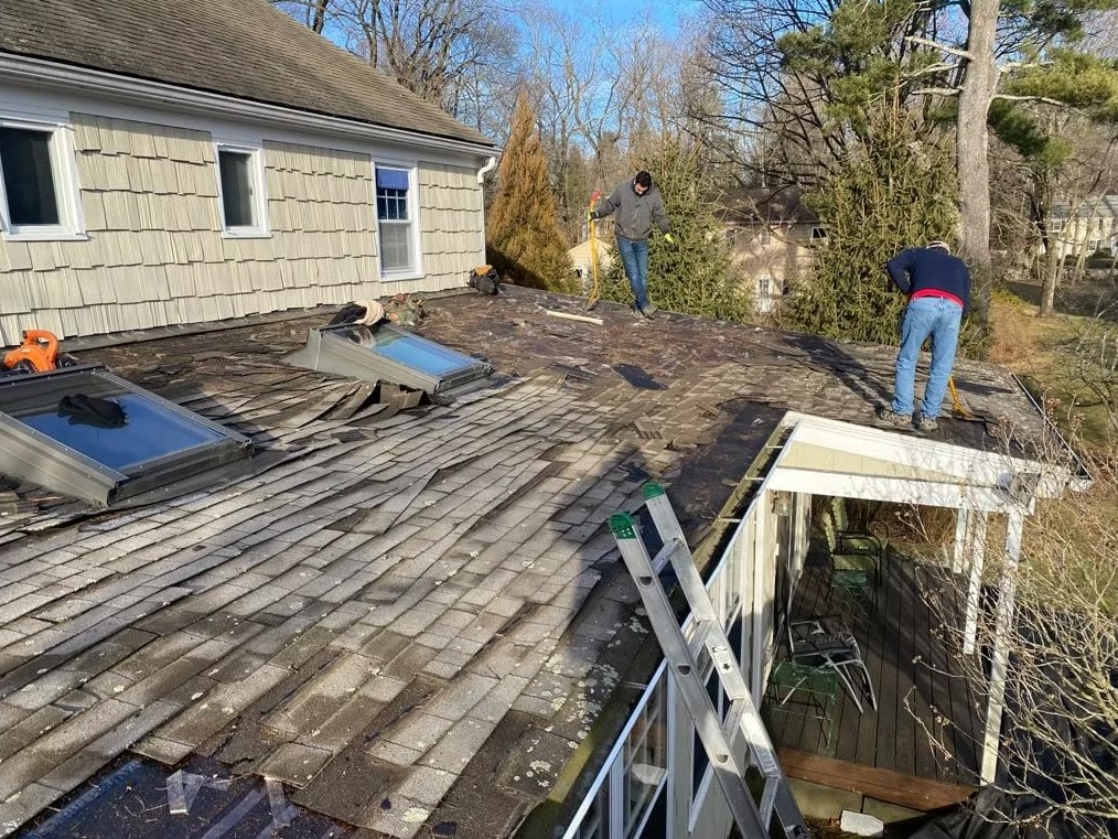 RC Carpentry & Roofing crew performing emergency roof repair and shingle tear-off on a Fairfield County home