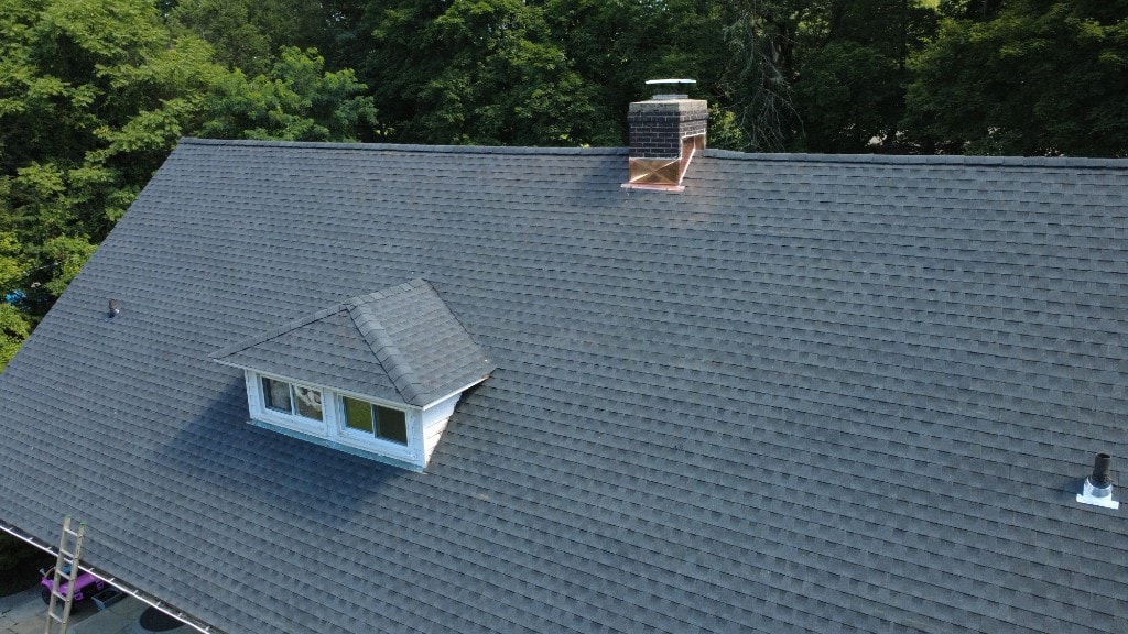 After — completed architectural asphalt shingle roof with copper chimney flashing and dormer on the same Fairfield County home
