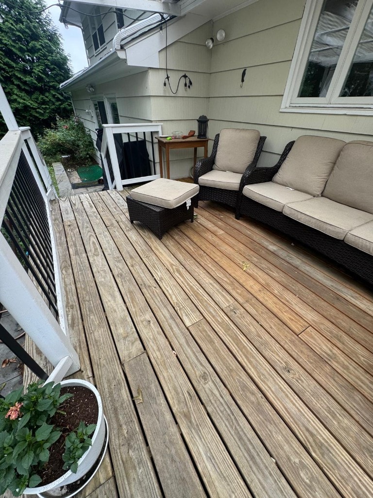 Finished wood deck with custom railings and outdoor living space by RC Carpentry & Roofing