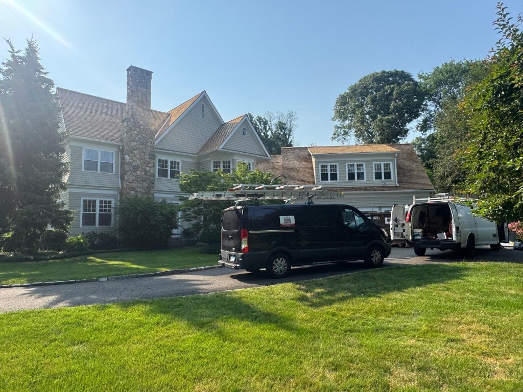 RC Carpentry & Roofing service vans at a large Fairfield County residential roofing project