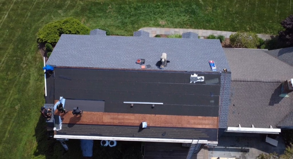 Aerial view of roof replacement in progress — underlayment and shingle installation on a Fairfield County home