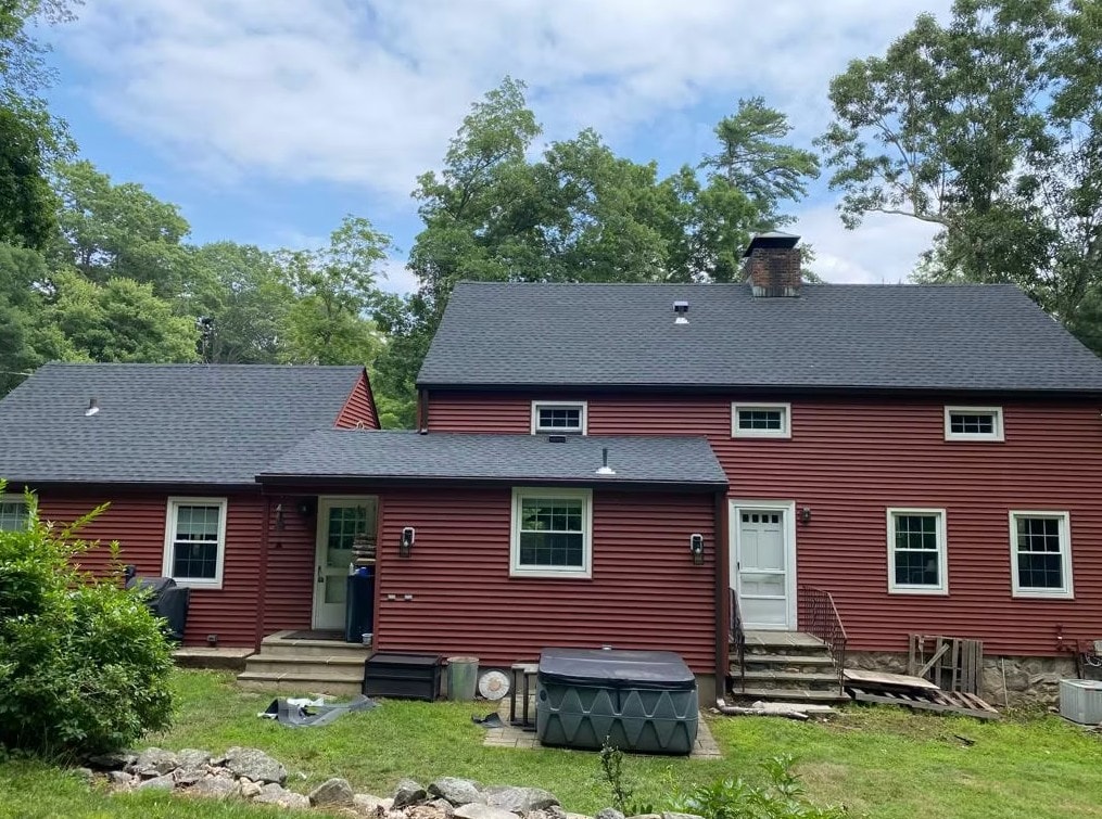 Completed asphalt roof and red siding installation on a Connecticut residential home